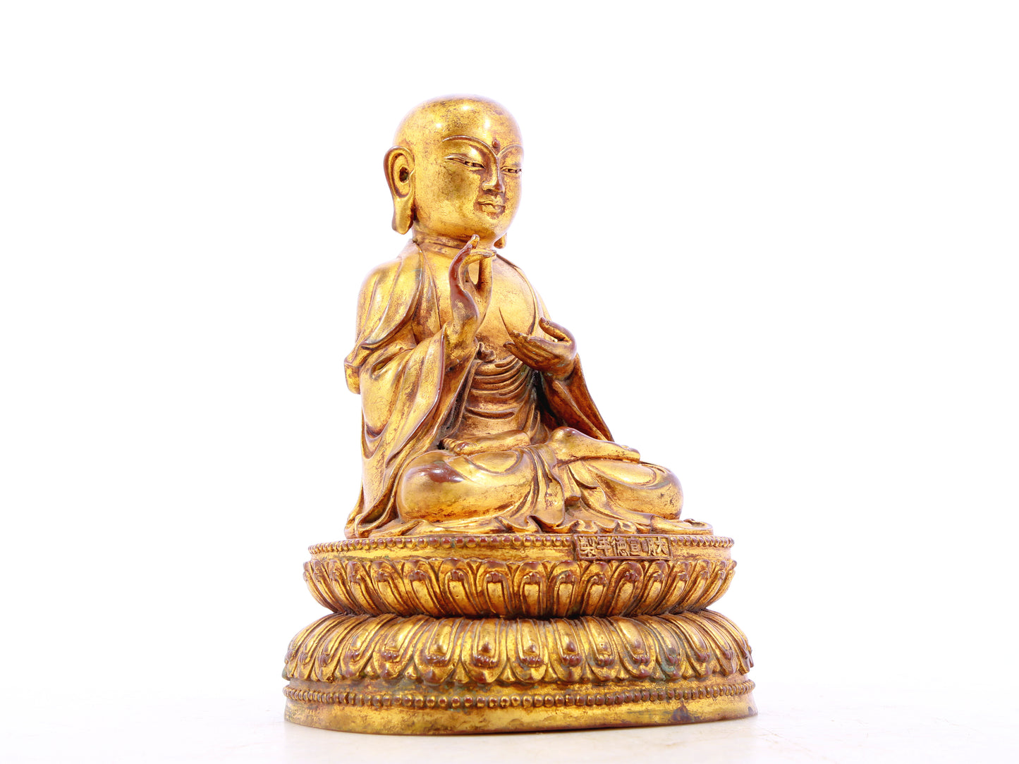 A solemn gilt bronze statue of the guru