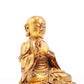 A solemn gilt bronze statue of the guru