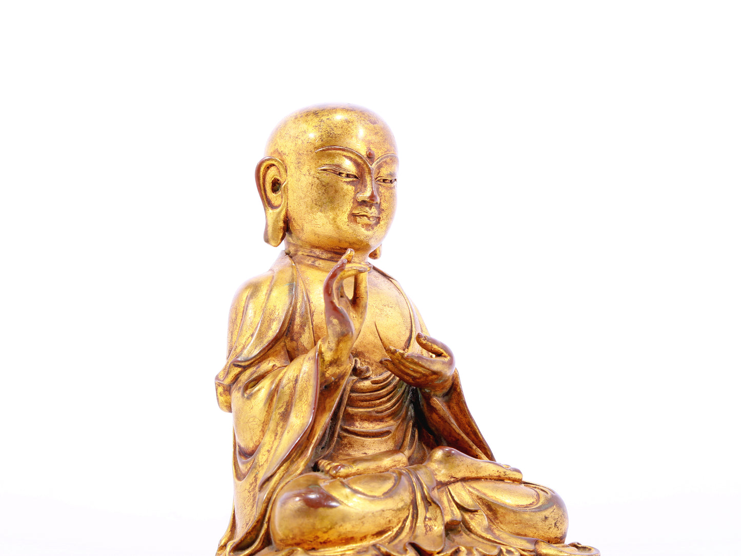 A solemn gilt bronze statue of the guru