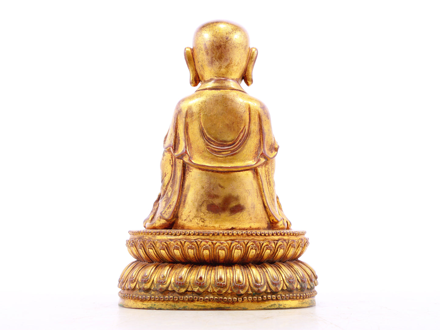 A solemn gilt bronze statue of the guru