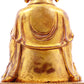 A solemn gilt bronze statue of the guru