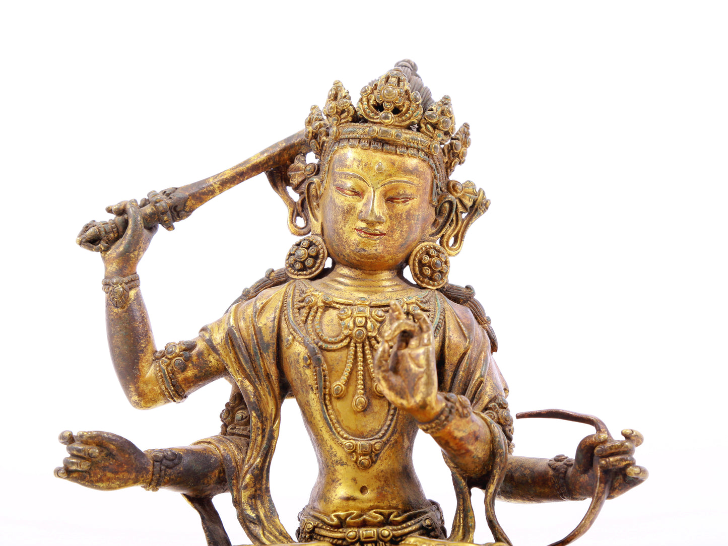 A serene gilt bronze statue of Manjusri with four arms