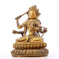 A serene gilt bronze statue of Manjusri with four arms