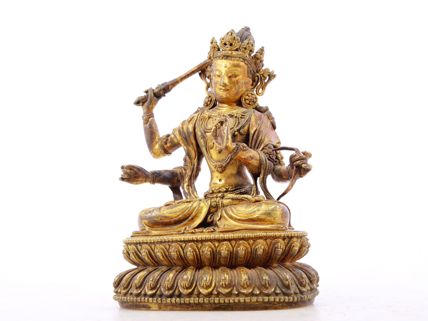 A serene gilt bronze statue of Manjusri with four arms