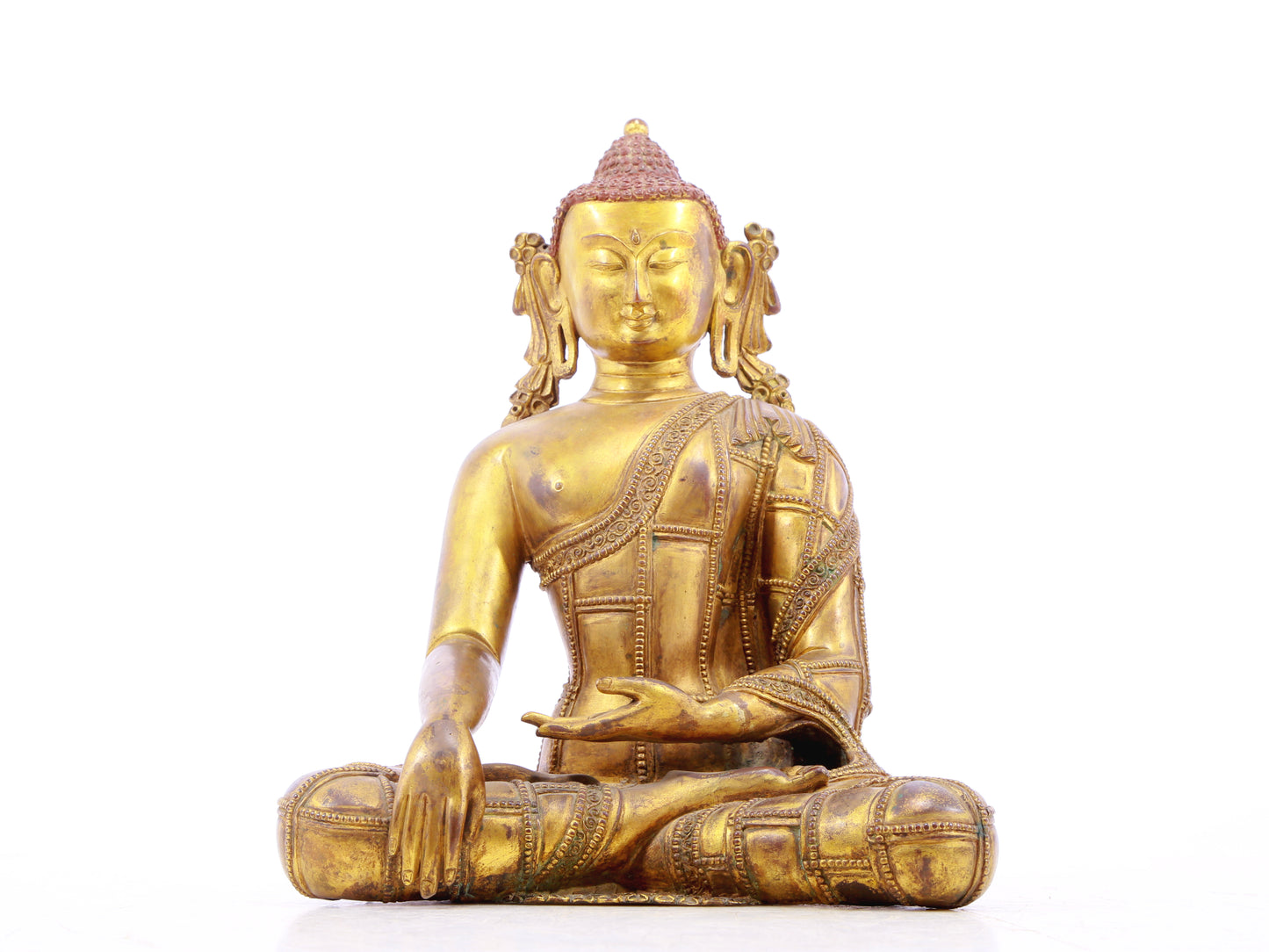 A solemn gilt bronze statue of Gautama Buddha