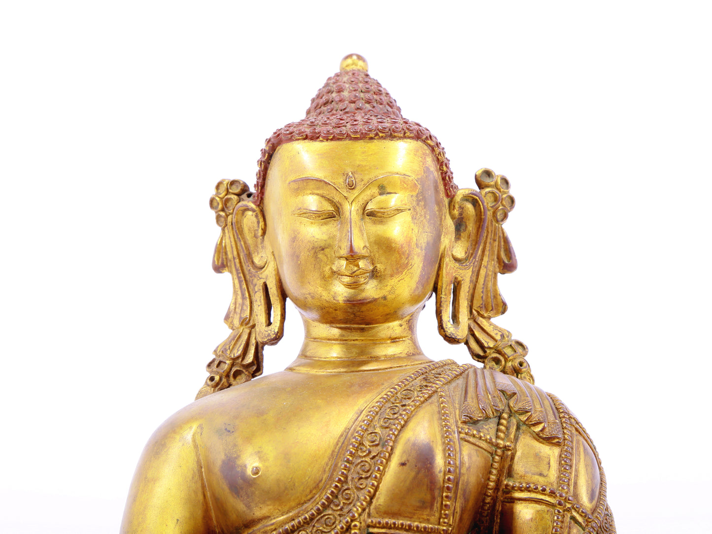 A solemn gilt bronze statue of Gautama Buddha