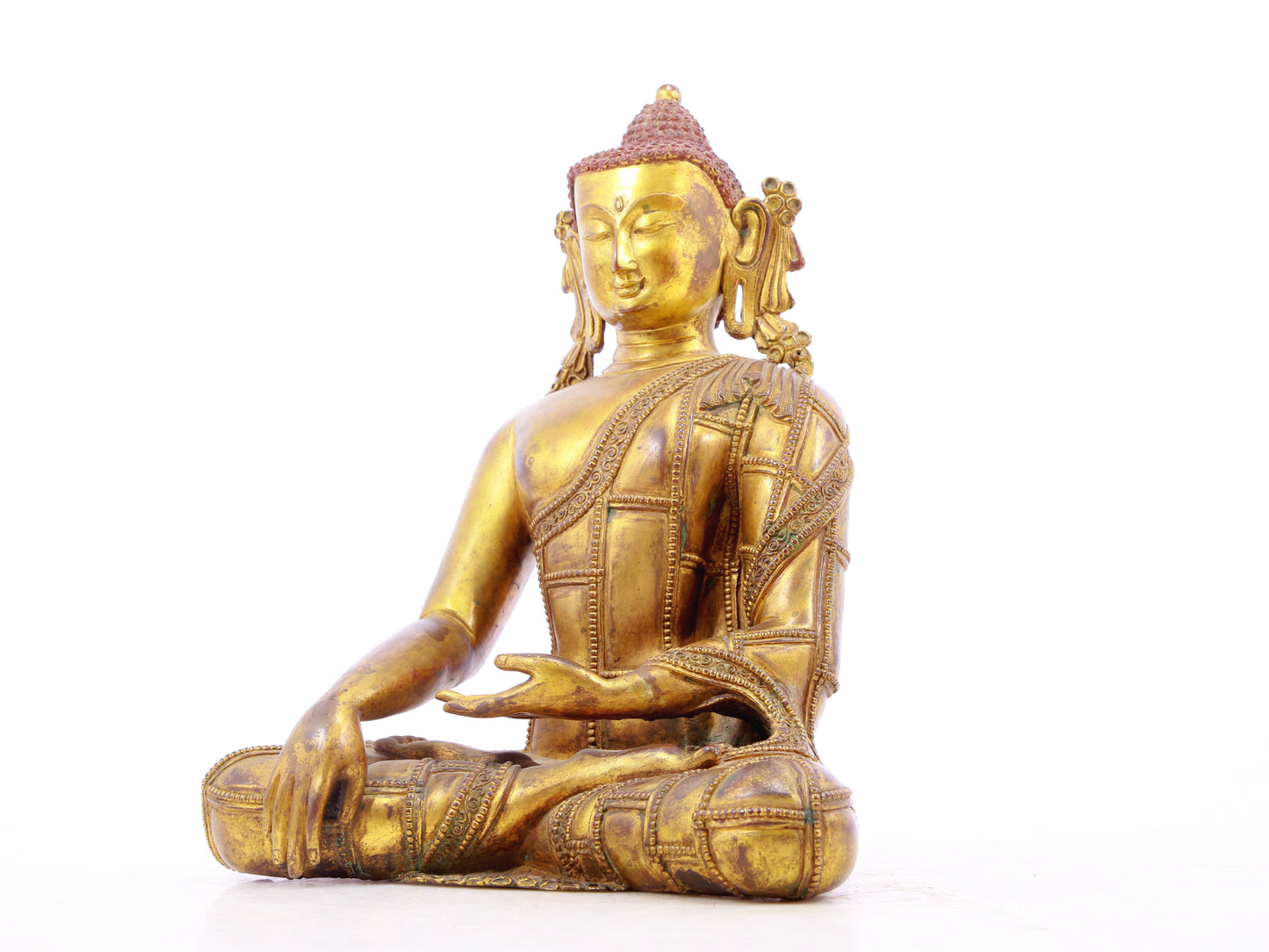 A solemn gilt bronze statue of Gautama Buddha