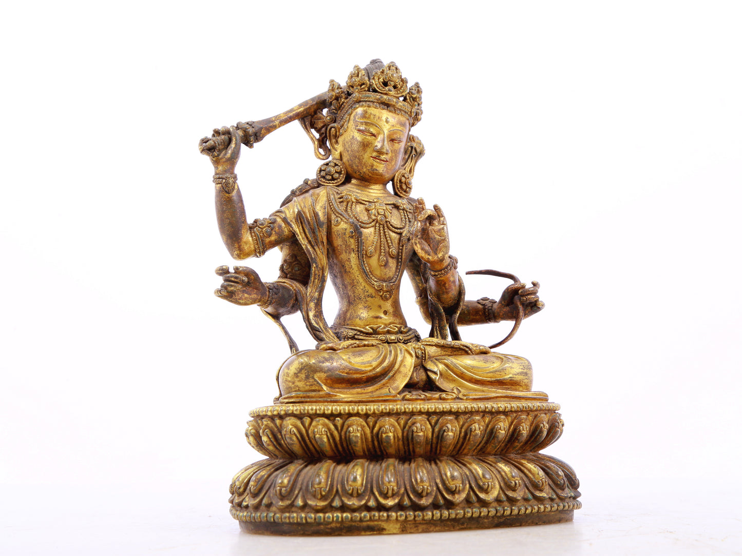 A serene gilt bronze statue of Manjusri with four arms