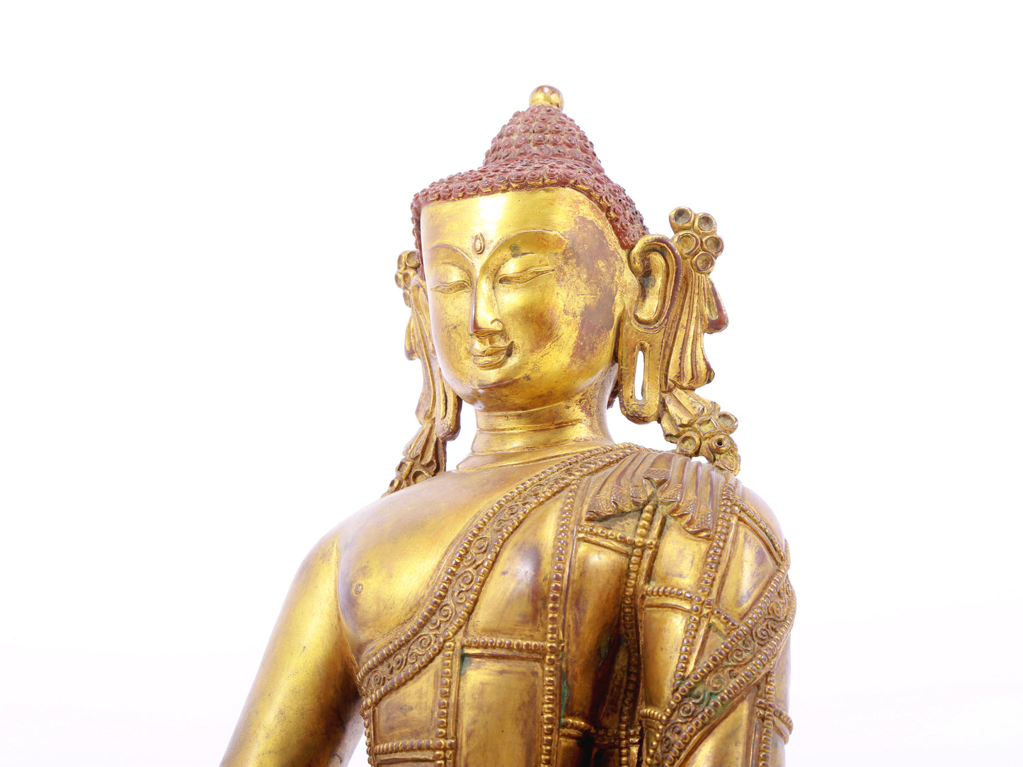 A solemn gilt bronze statue of Gautama Buddha