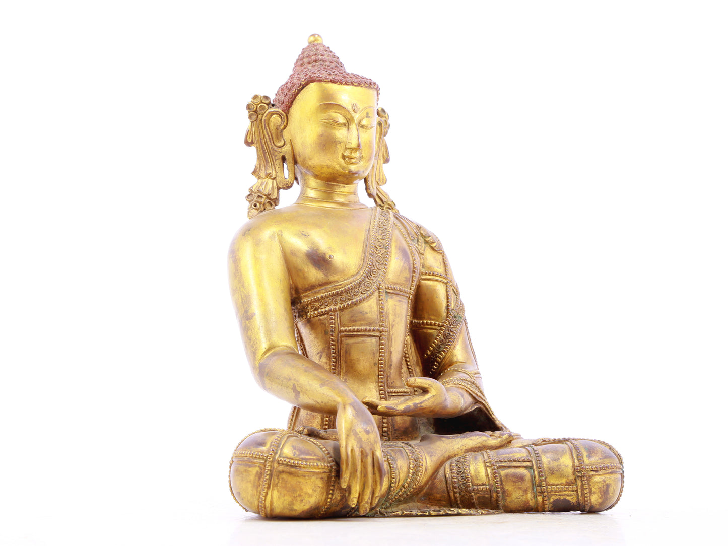 A solemn gilt bronze statue of Gautama Buddha