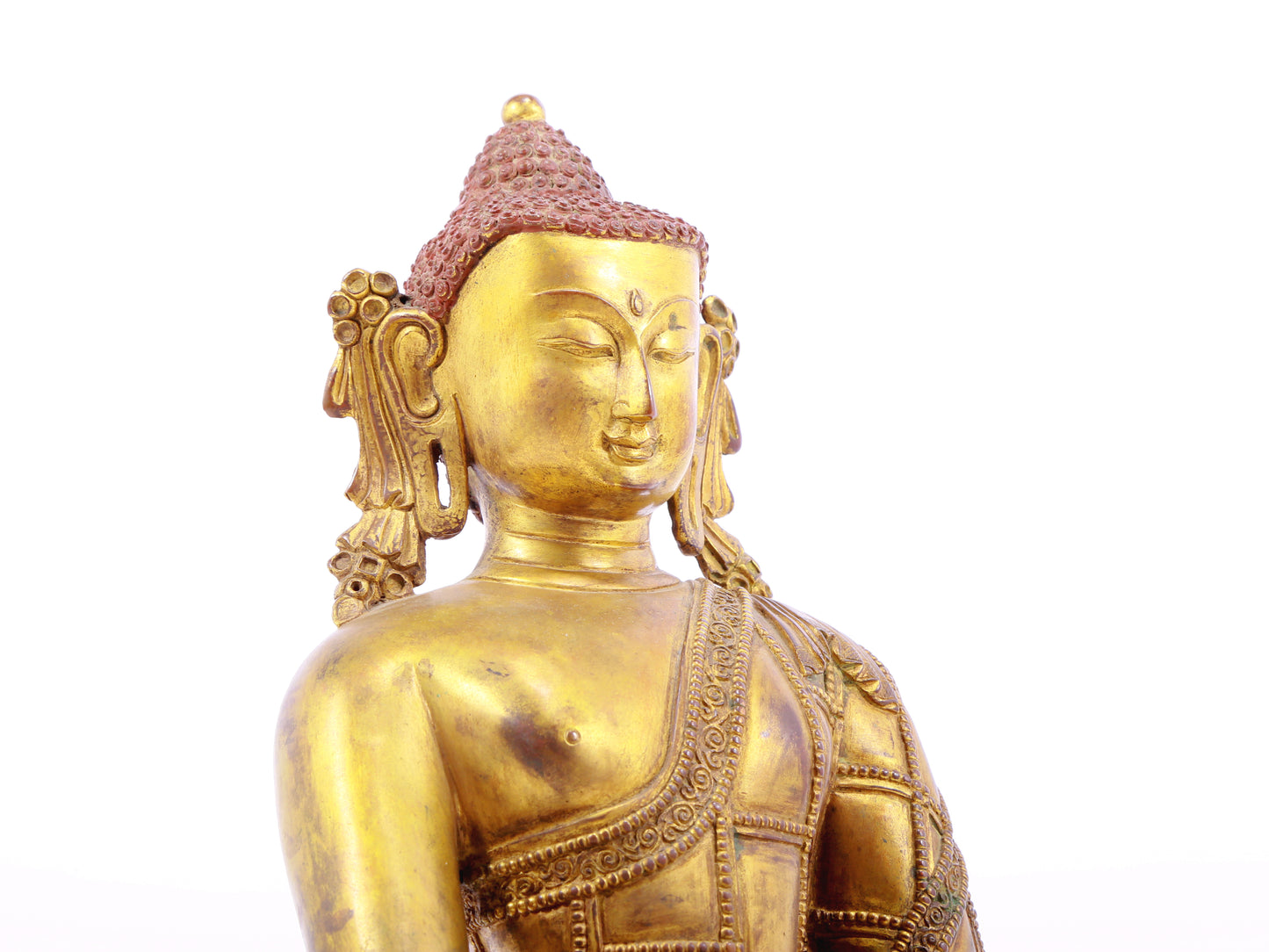 A solemn gilt bronze statue of Gautama Buddha