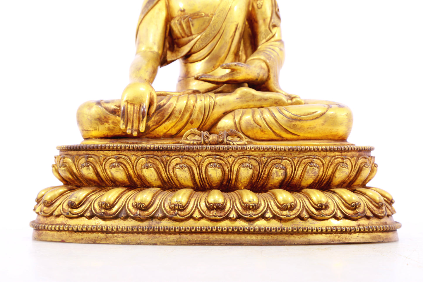 A solemn gilt bronze statue of Gautama Buddha