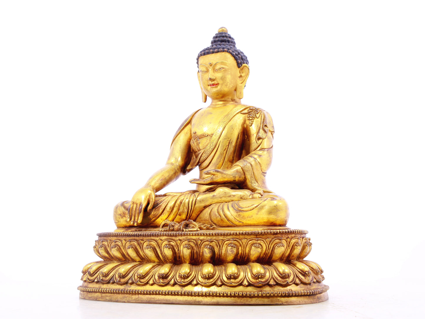 A solemn gilt bronze statue of Gautama Buddha