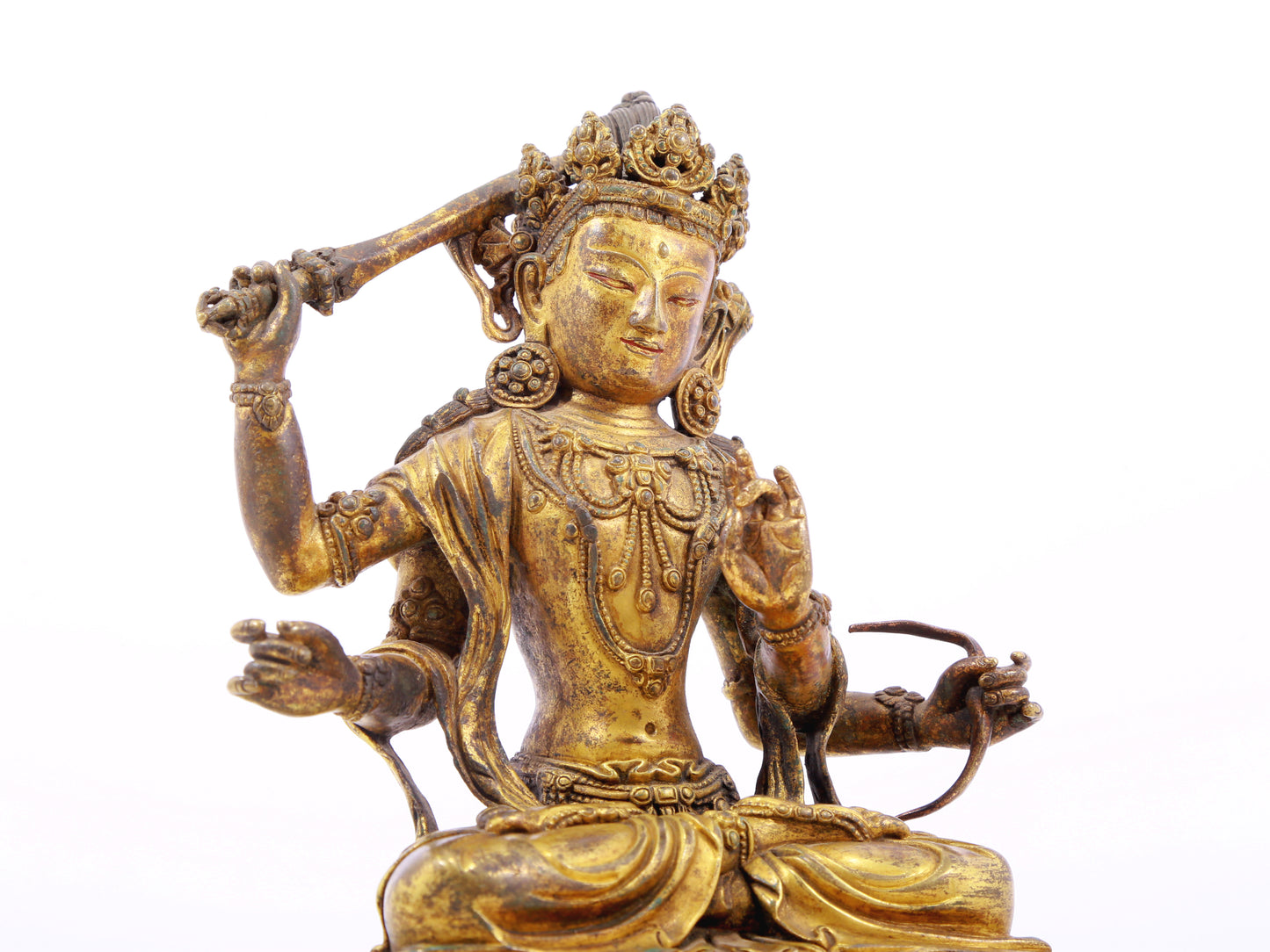 A serene gilt bronze statue of Manjusri with four arms