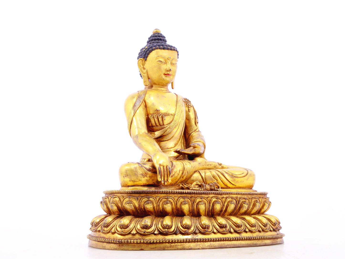 A solemn gilt bronze statue of Gautama Buddha