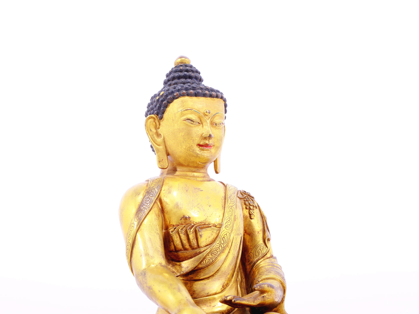 A solemn gilt bronze statue of Gautama Buddha