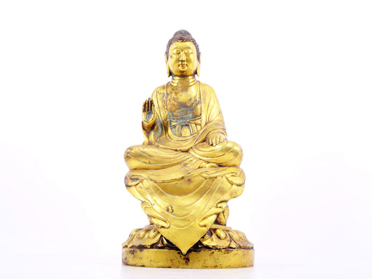 A solemn gilt bronze statue of Gautama Buddha