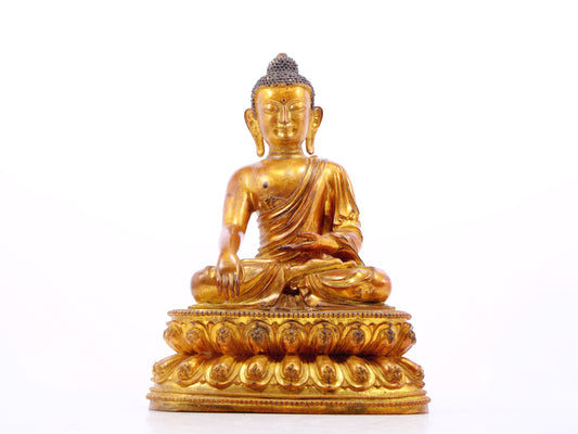 A solemn gilt bronze statue of Gautama Buddha