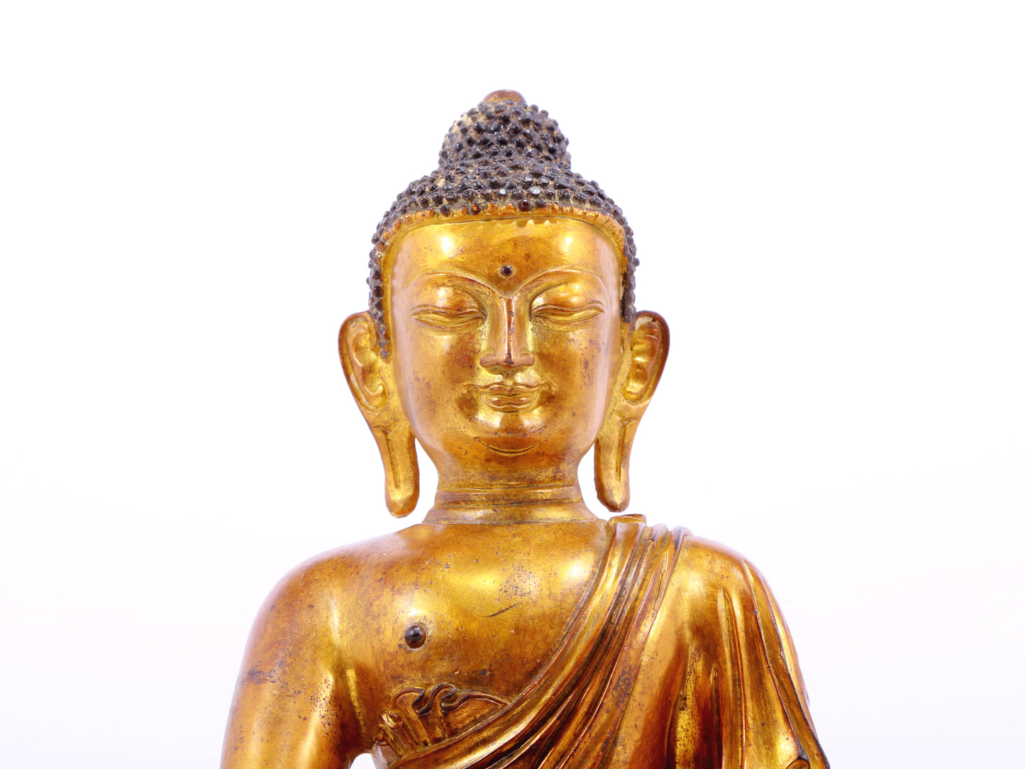 A solemn gilt bronze statue of Gautama Buddha