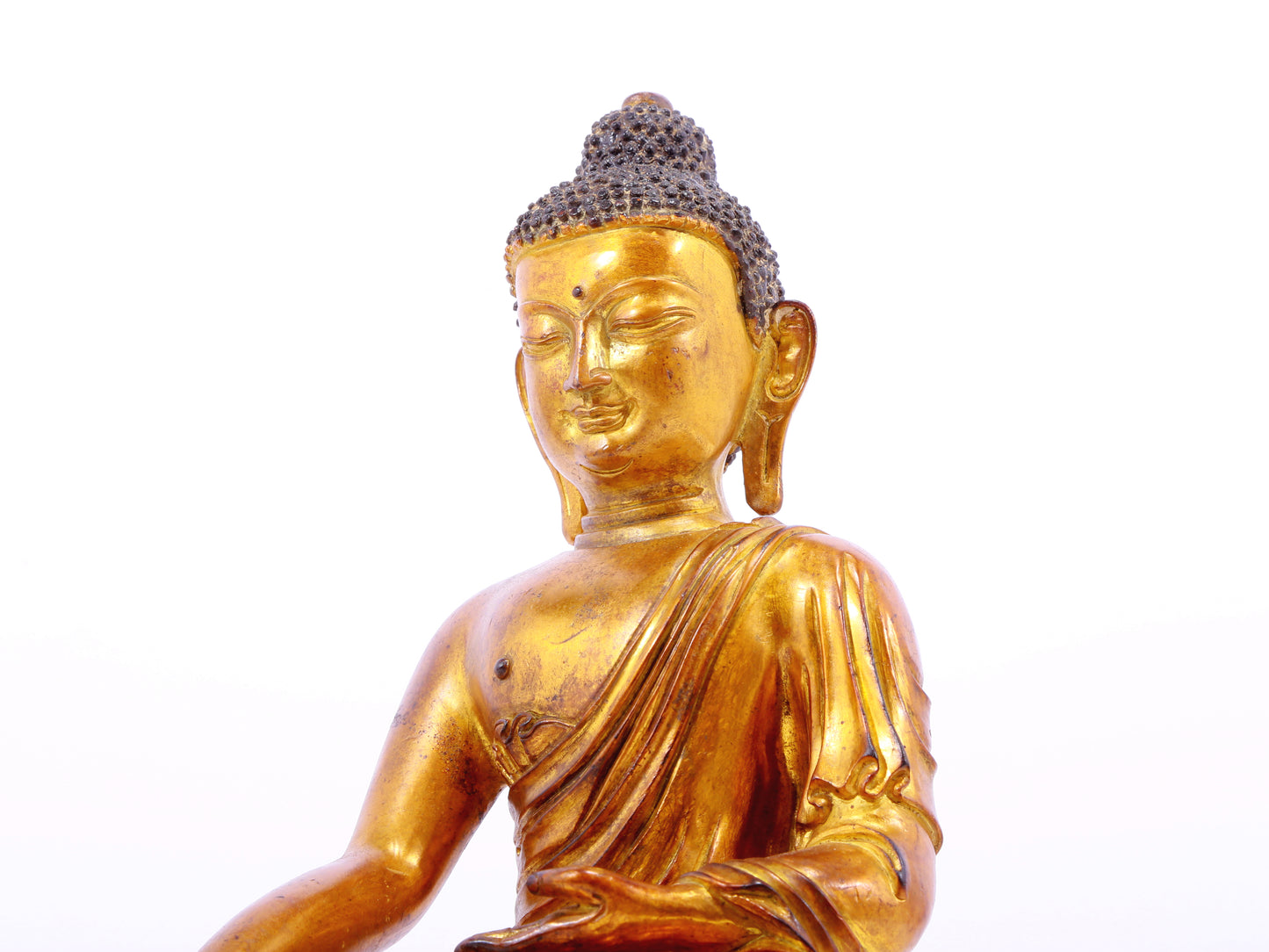 A solemn gilt bronze statue of Gautama Buddha