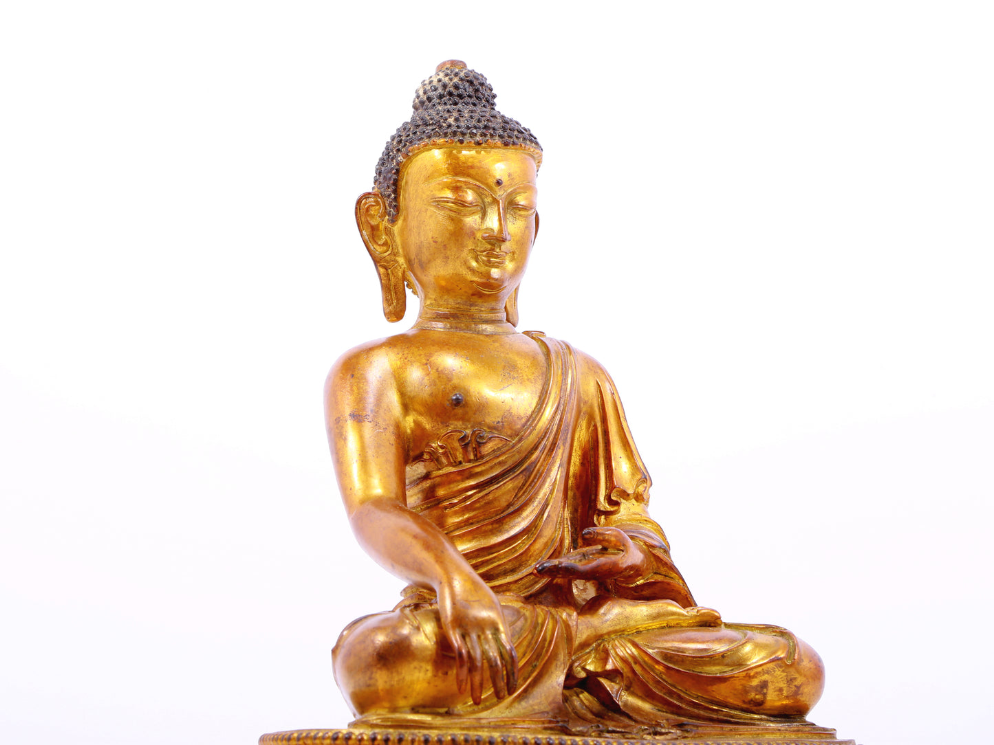 A solemn gilt bronze statue of Gautama Buddha