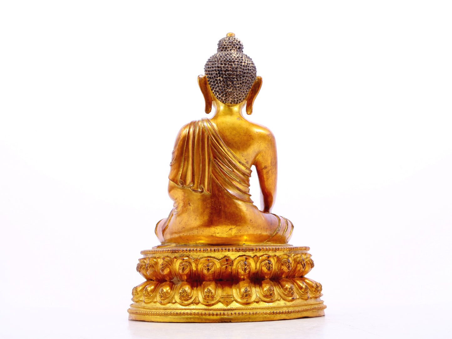 A solemn gilt bronze statue of Gautama Buddha