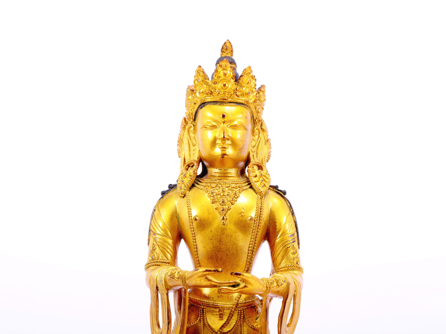 A solemn gilt bronze Bodhisattva stands