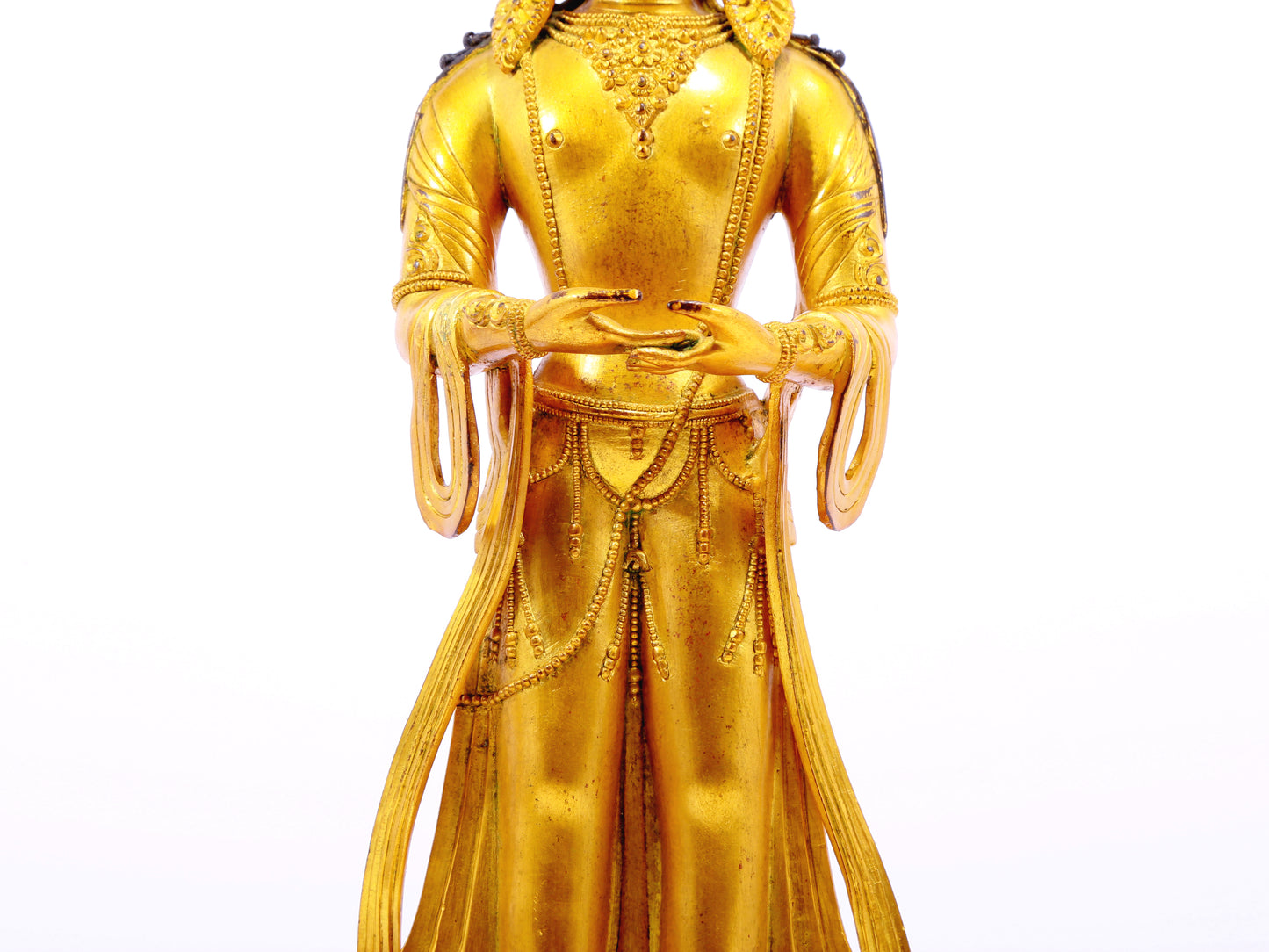 A solemn gilt bronze Bodhisattva stands