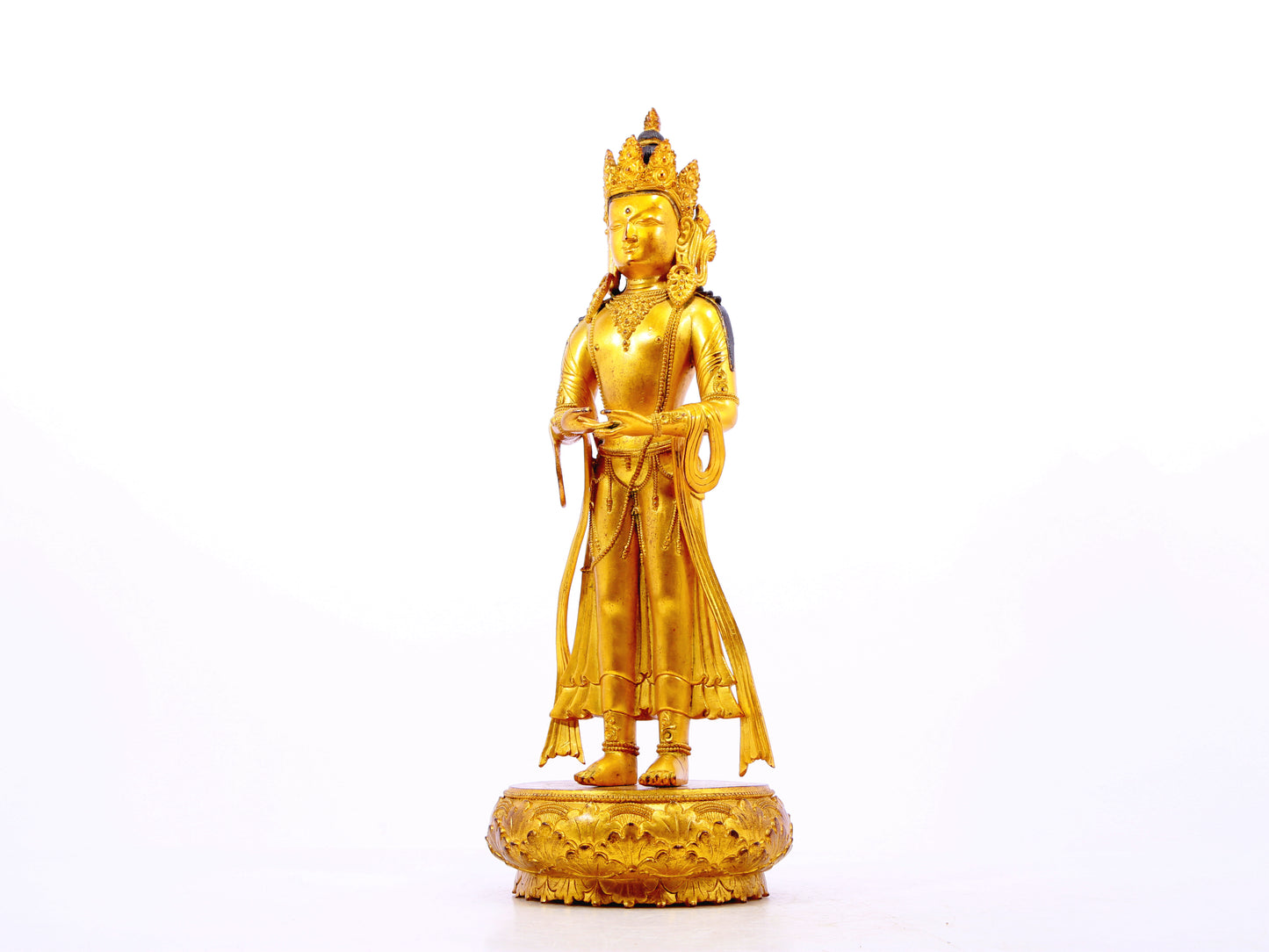 A solemn gilt bronze Bodhisattva stands