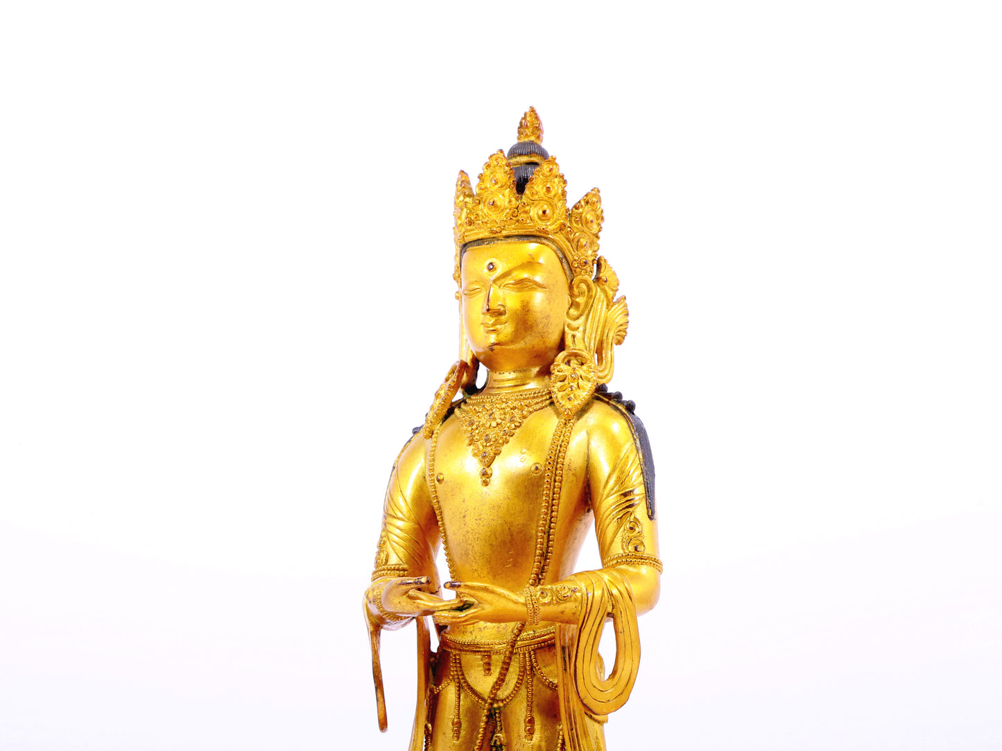 A solemn gilt bronze Bodhisattva stands