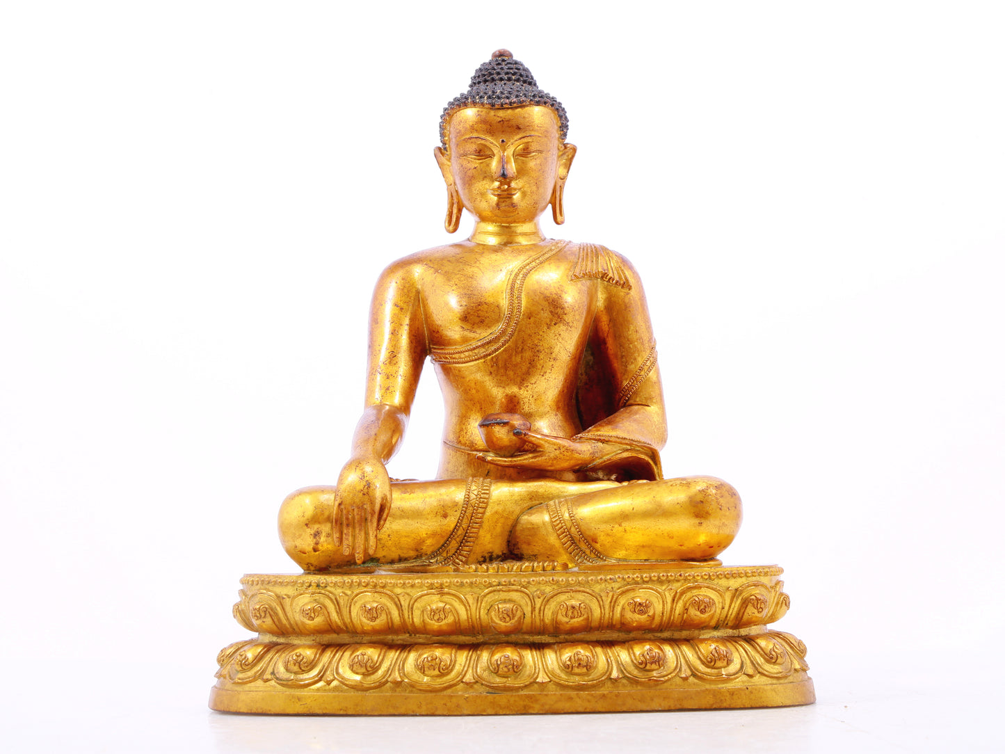 A solemn gilt bronze statue of Gautama Buddha