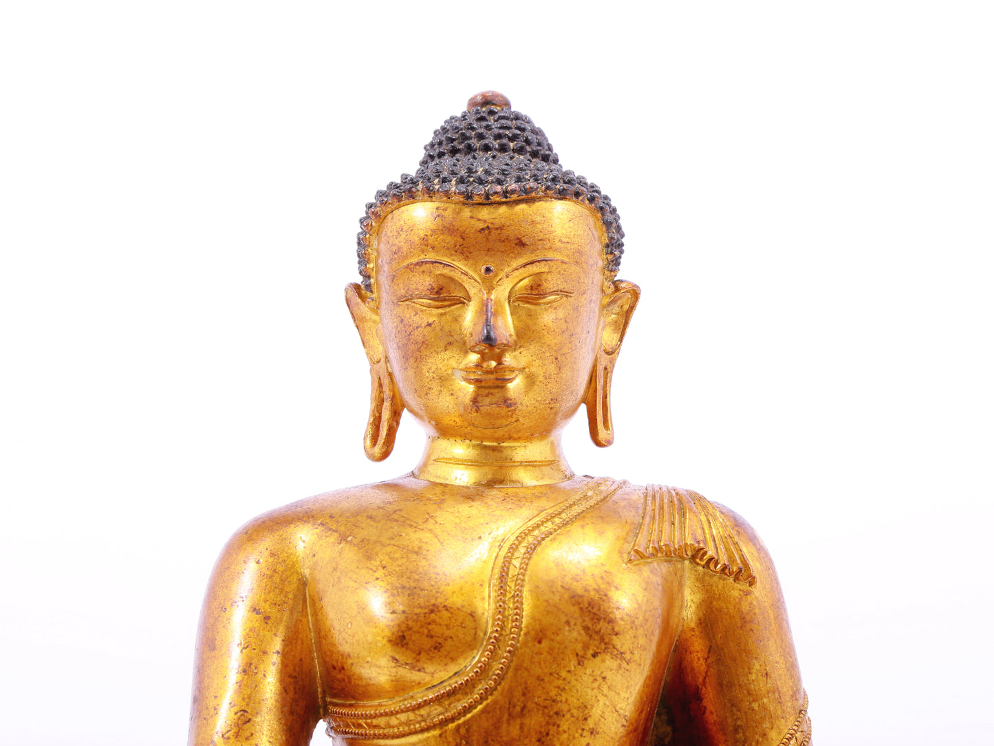 A solemn gilt bronze statue of Gautama Buddha