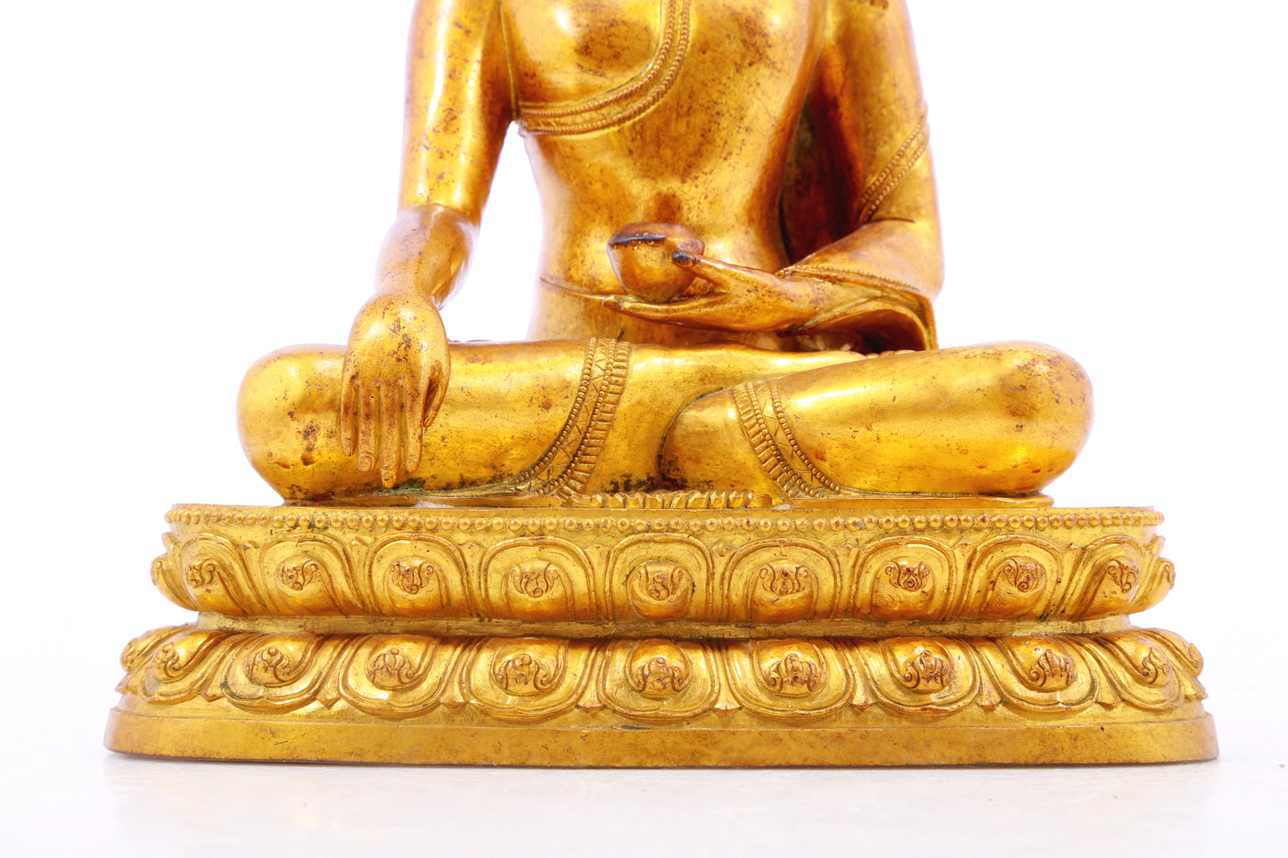 A solemn gilt bronze statue of Gautama Buddha