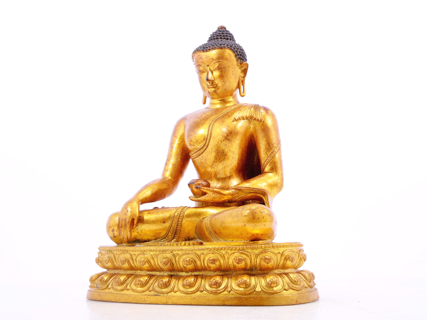 A solemn gilt bronze statue of Gautama Buddha