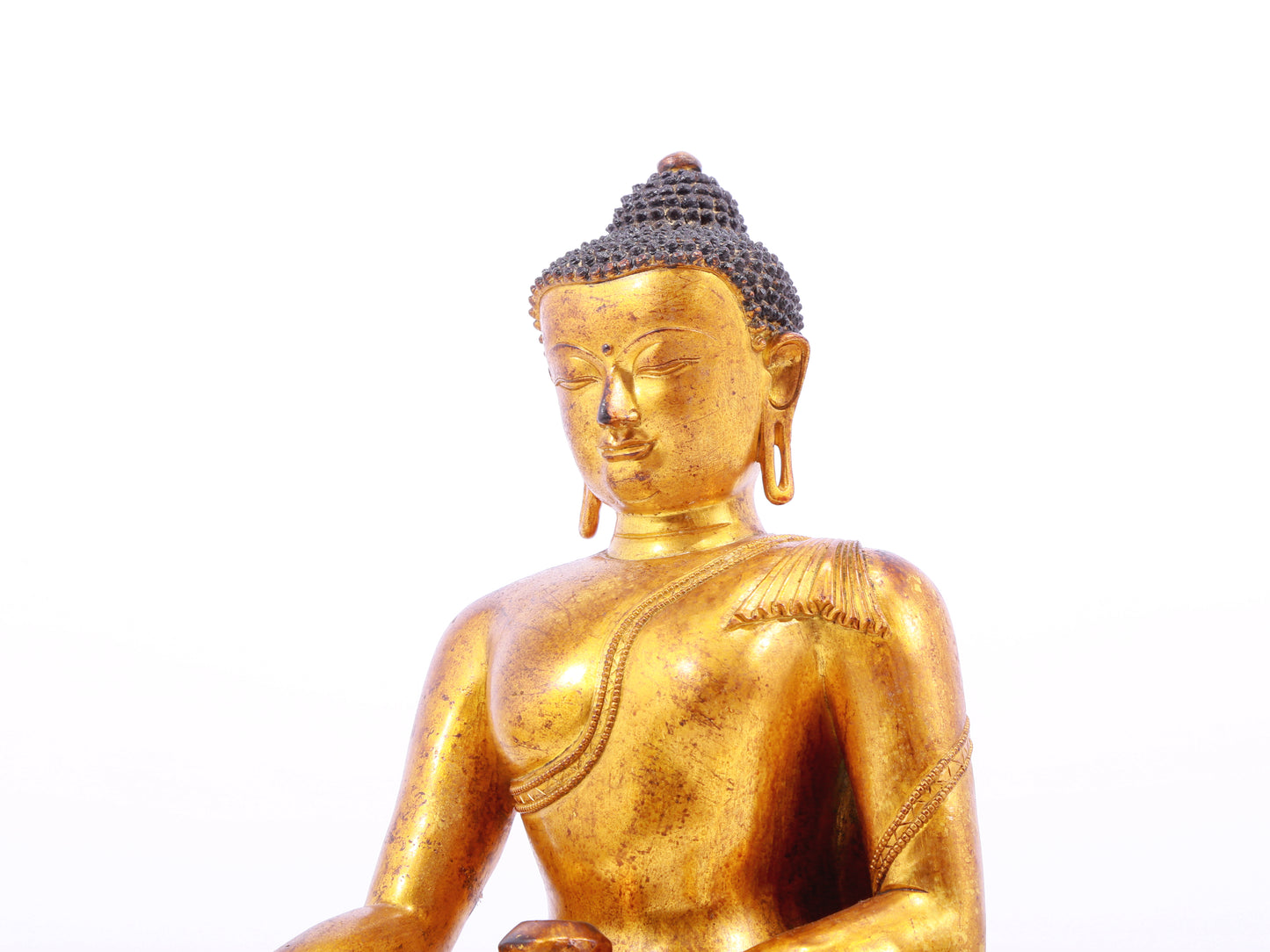 A solemn gilt bronze statue of Gautama Buddha