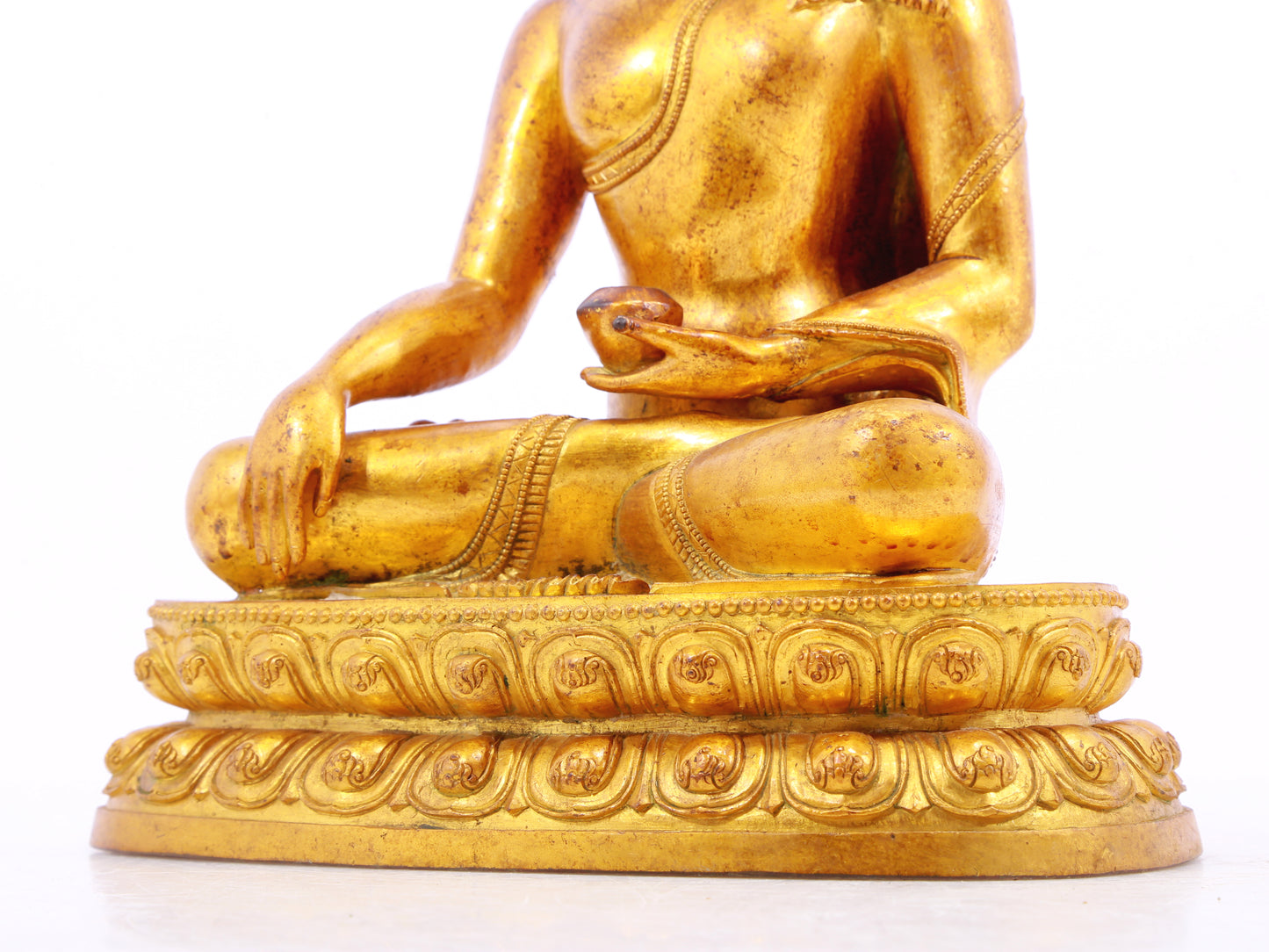 A solemn gilt bronze statue of Gautama Buddha