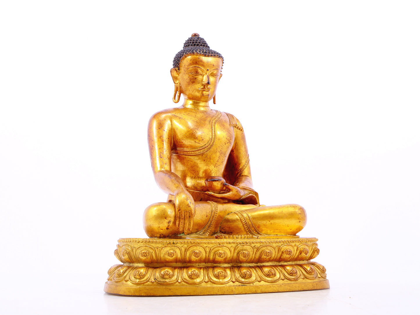 A solemn gilt bronze statue of Gautama Buddha