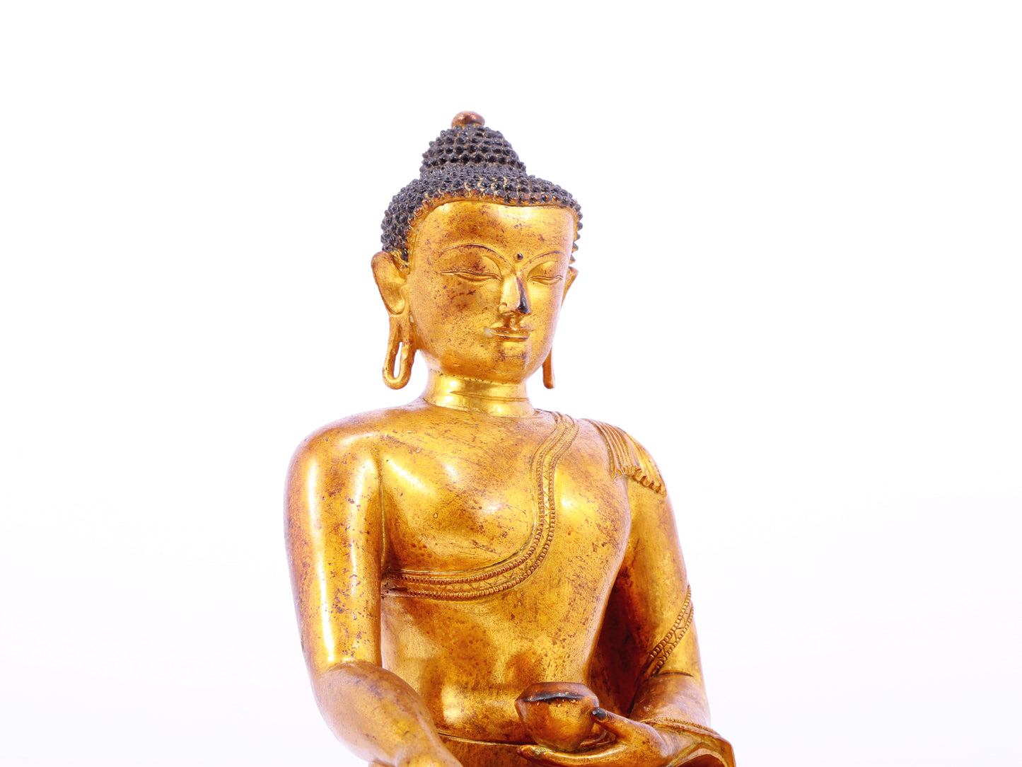 A solemn gilt bronze statue of Gautama Buddha