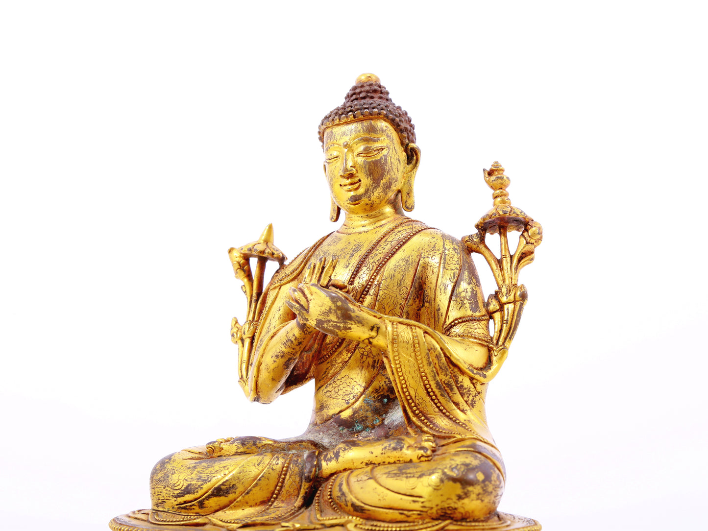 A serene gilt bronze statue of Gautama Buddha