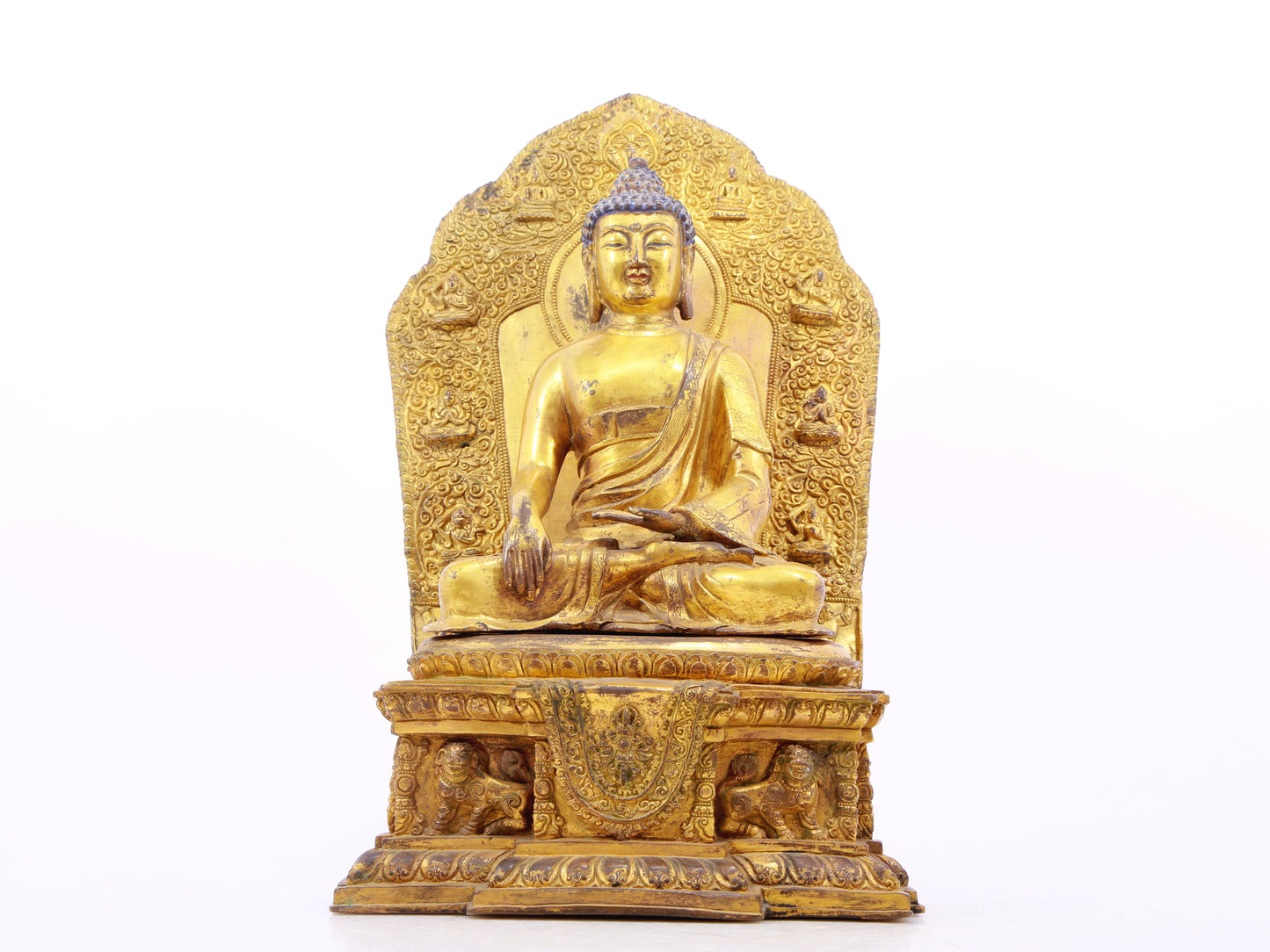 A solemn gilt bronze statue of Gautama Buddha