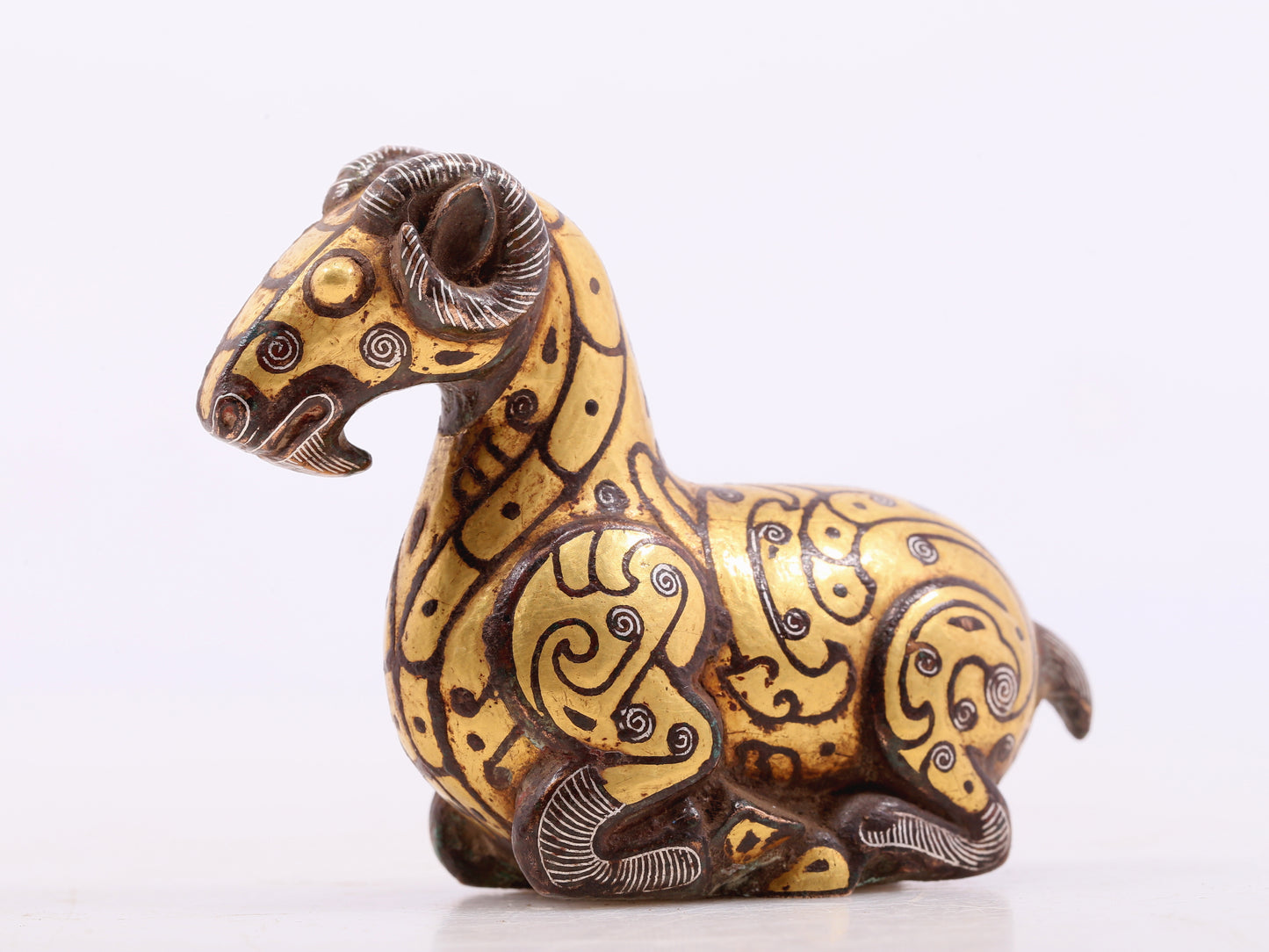 A pair of bronze inlaid gold and silver goat ornaments