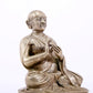 A majestic copper-silvered statue of the Guru