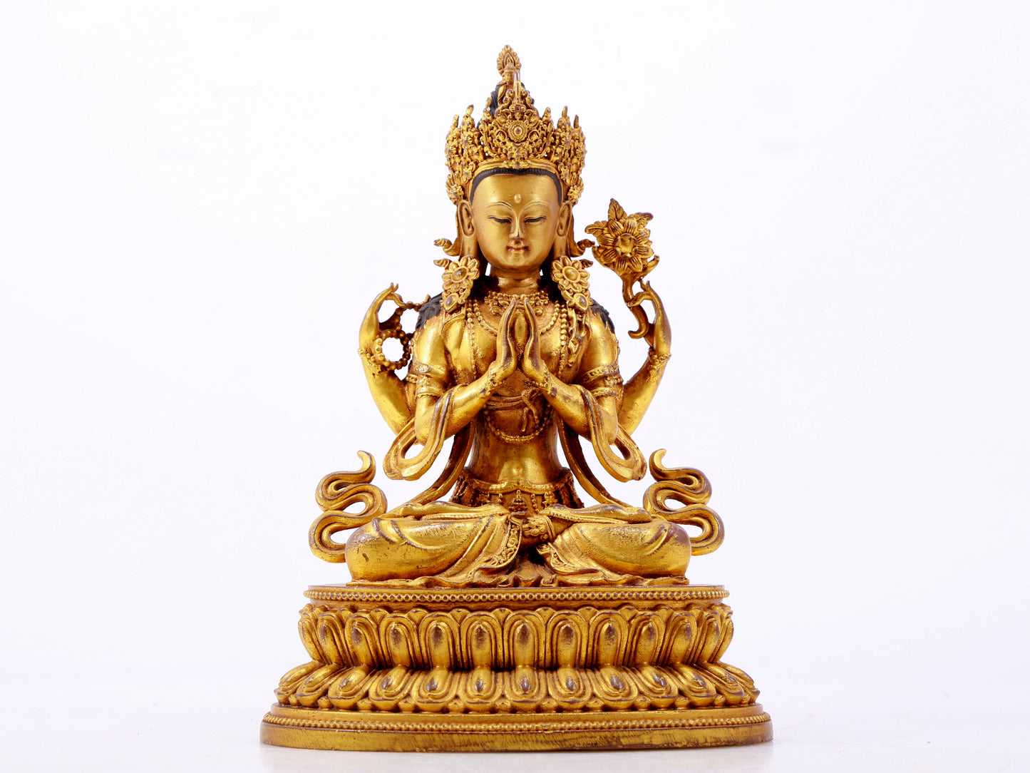 A majestic gilt bronze four-armed Guanyin statue