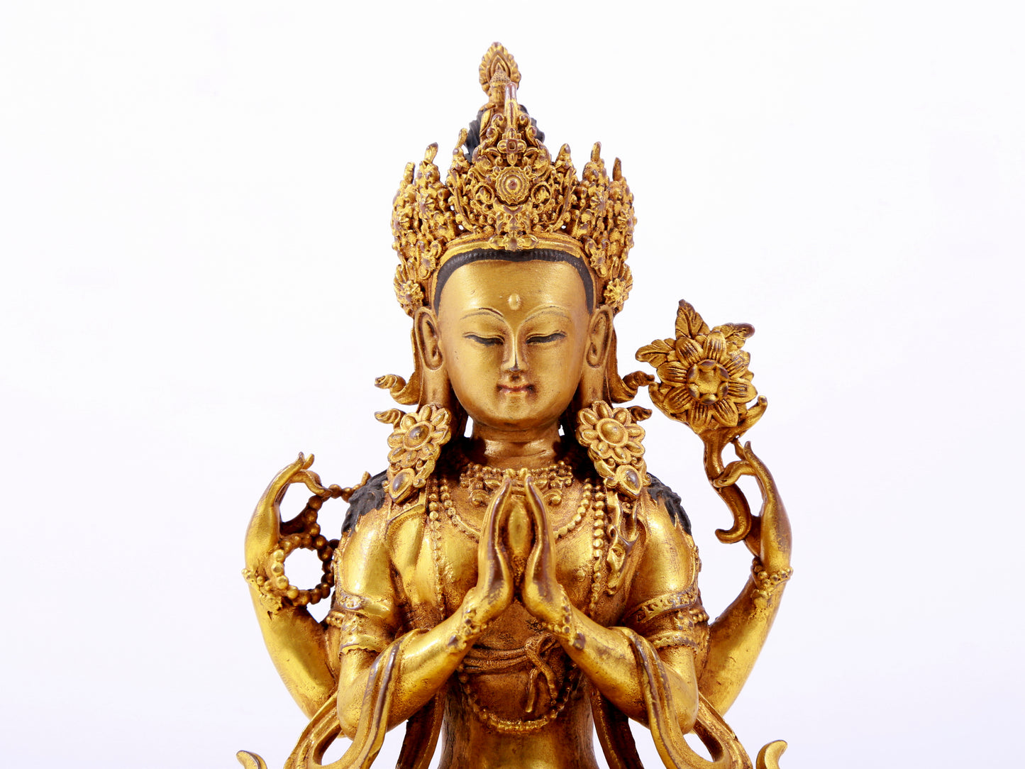 A majestic gilt bronze four-armed Guanyin statue