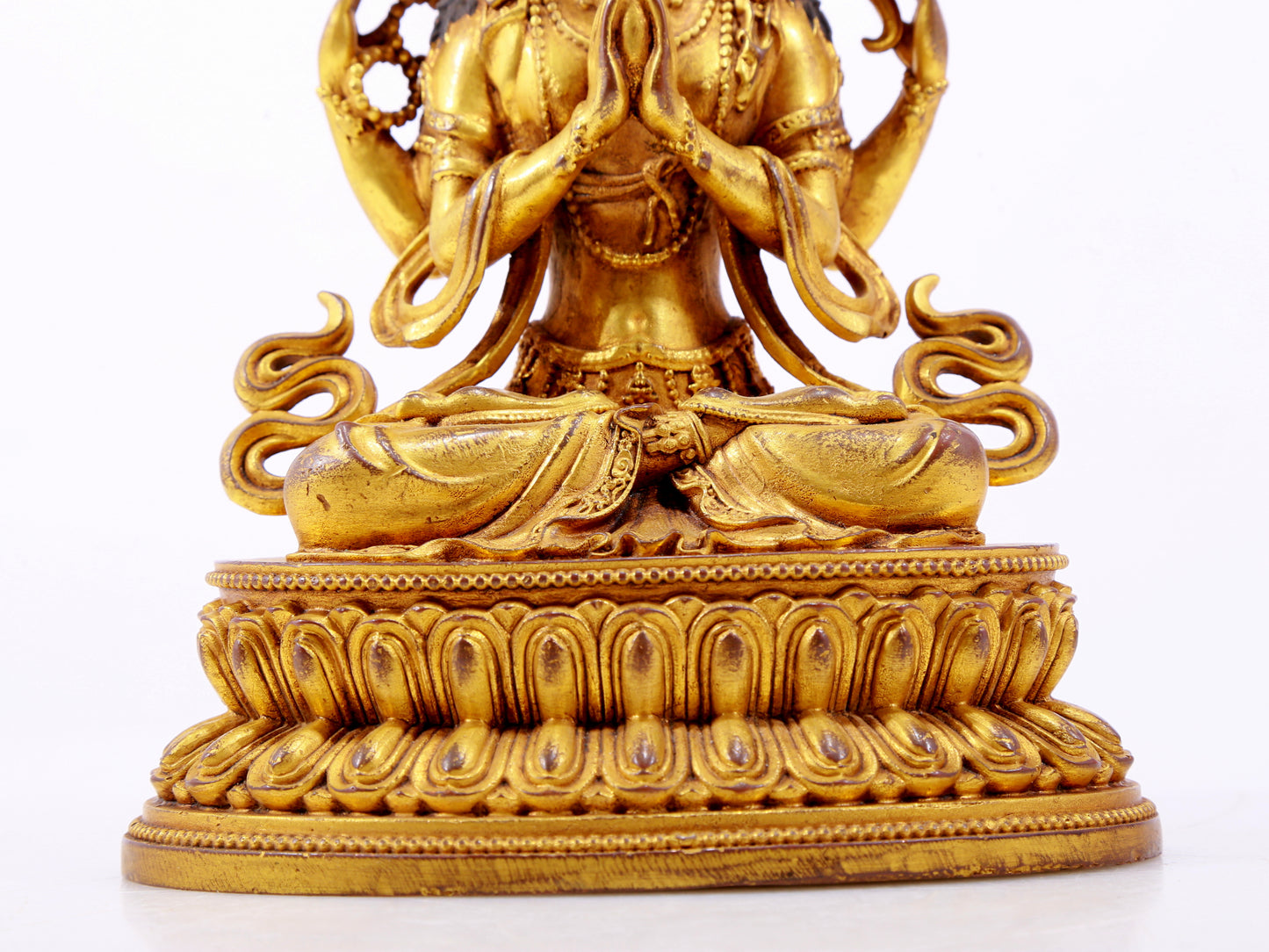 A majestic gilt bronze four-armed Guanyin statue