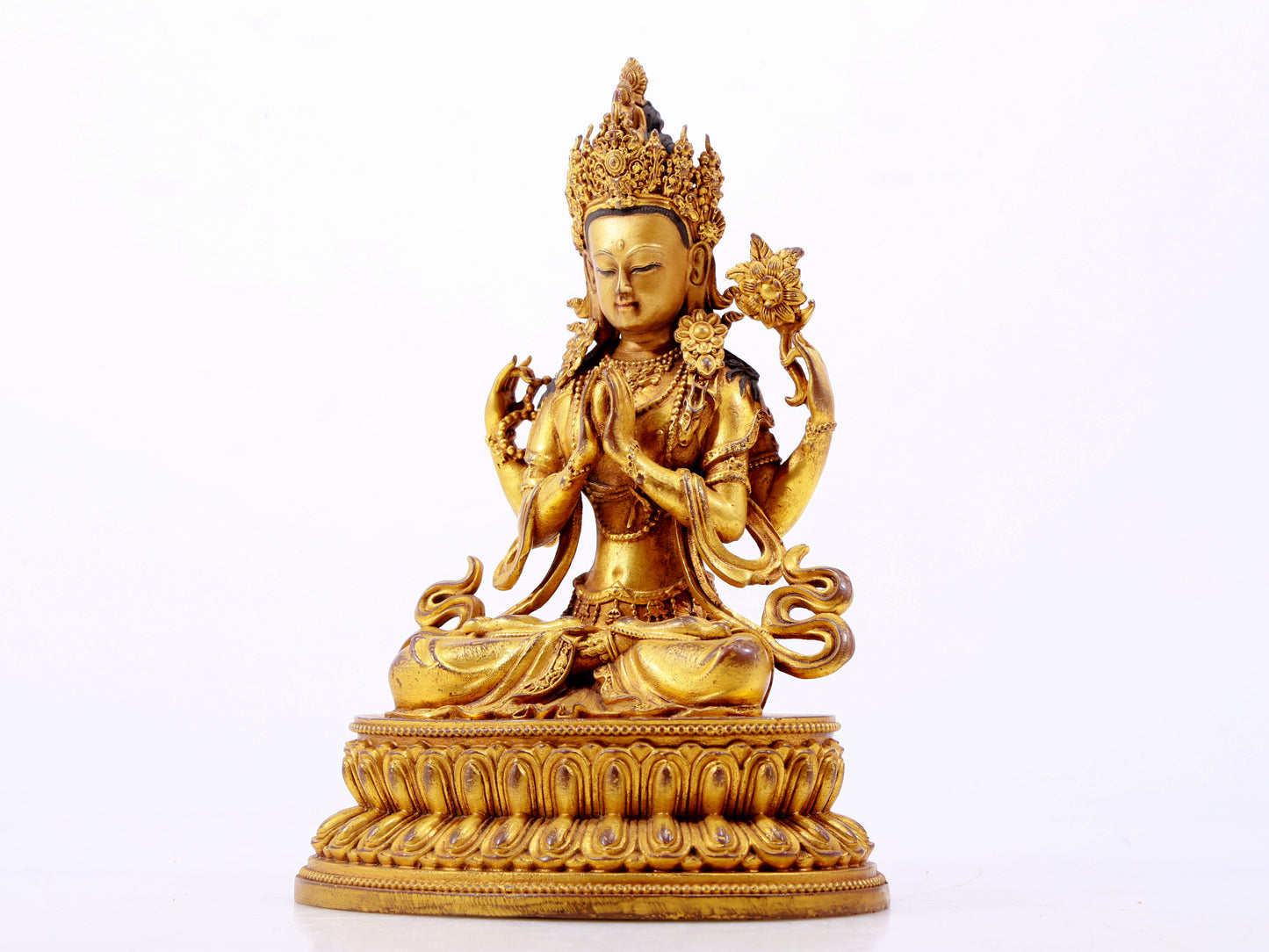 A majestic gilt bronze four-armed Guanyin statue