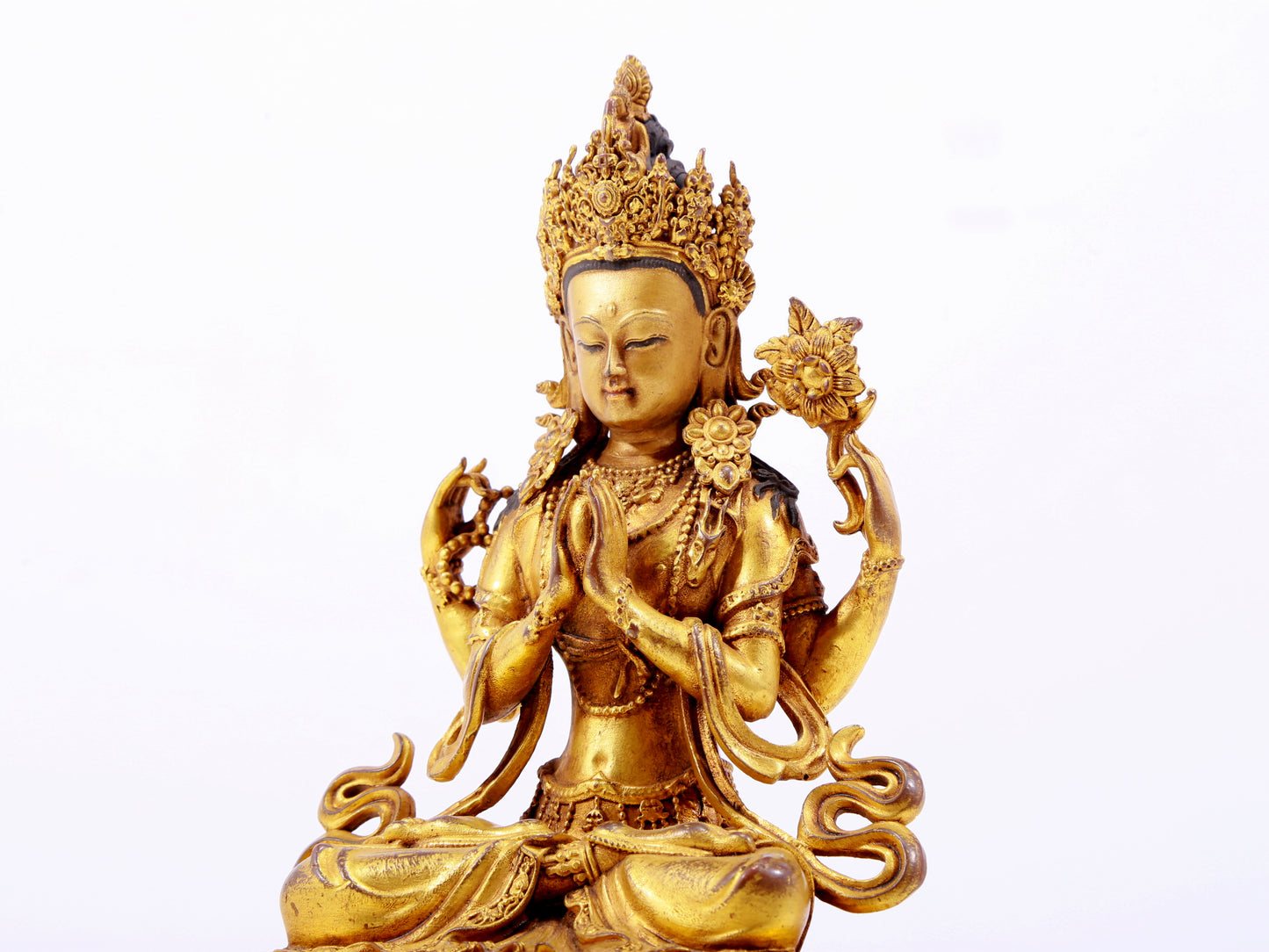 A majestic gilt bronze four-armed Guanyin statue