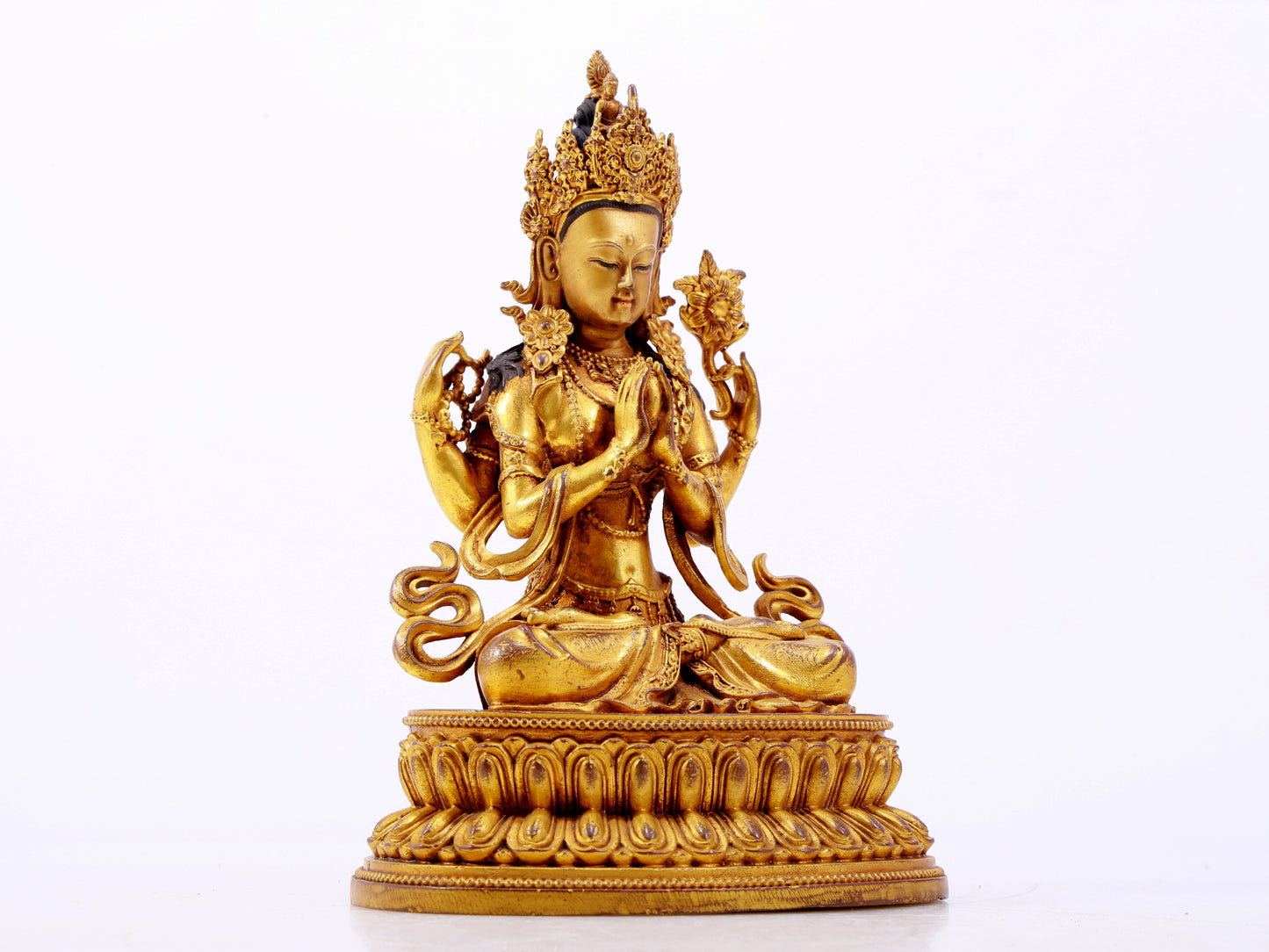 A majestic gilt bronze four-armed Guanyin statue