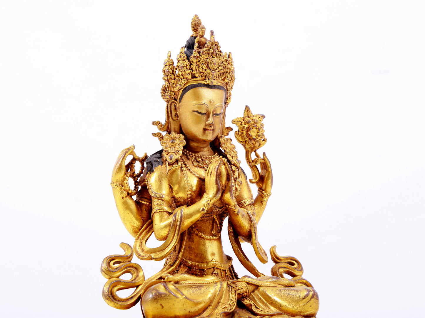 A majestic gilt bronze four-armed Guanyin statue