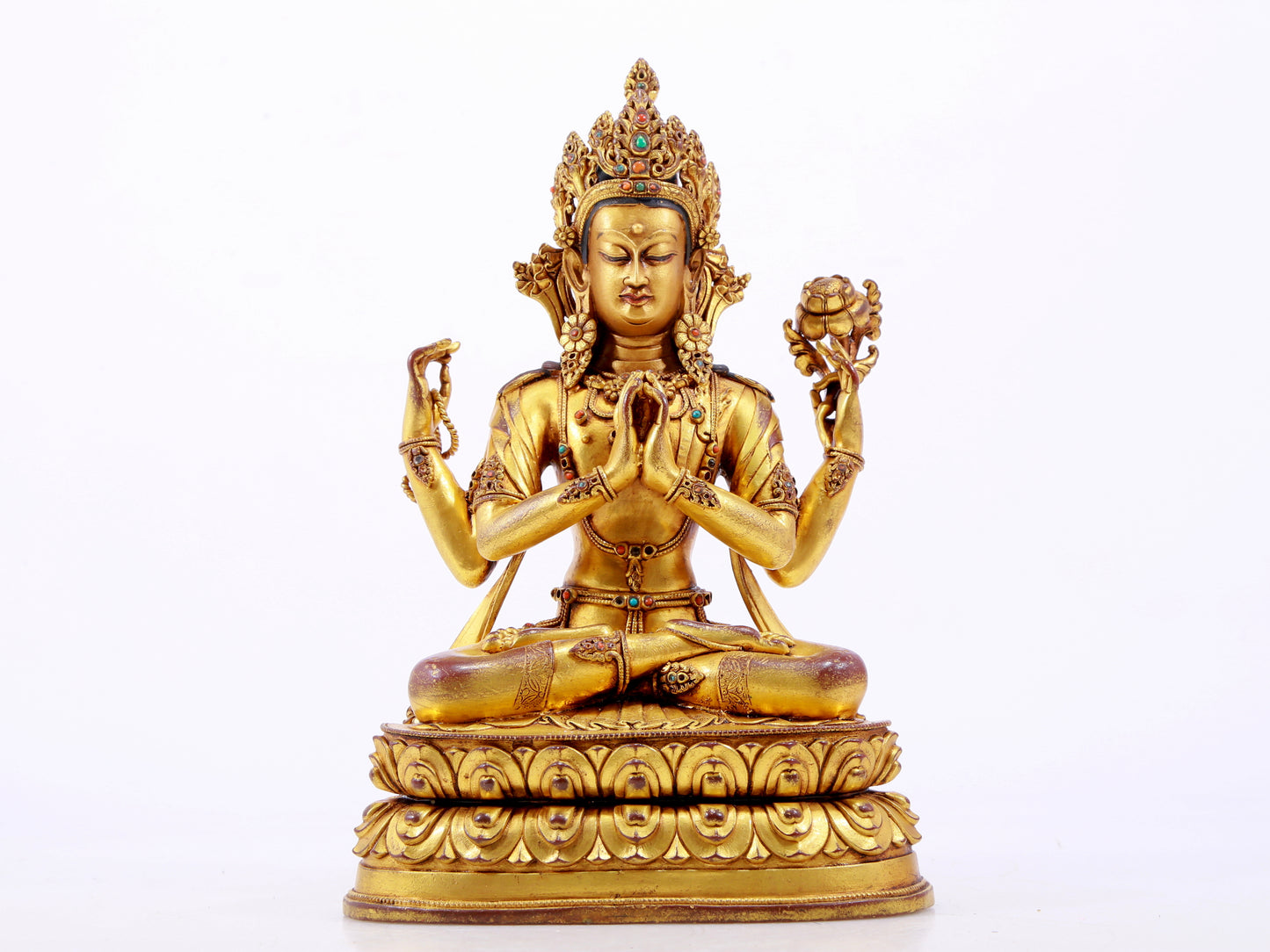 A solemn gilt bronze statue of Guanyin with four arms inlaid with hundreds of treasures